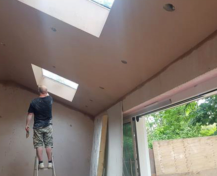 A plasterer plastering a ceiling in Croydon