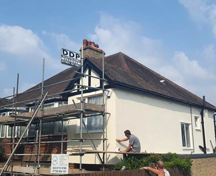 A painter and decorator painting the exterior of a house in Croydon